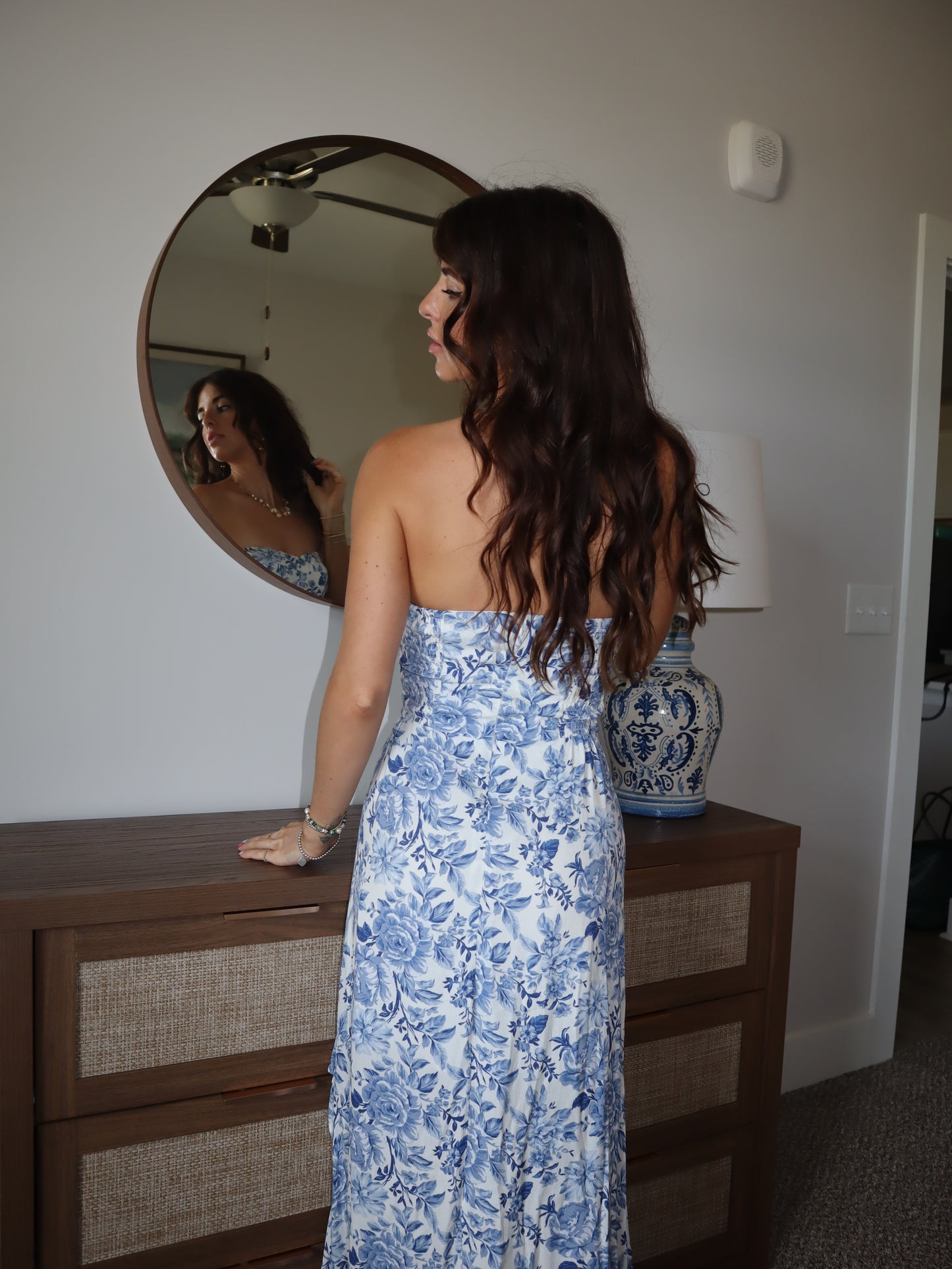 back of woman in blue floral strapless dress heading to a wedding.