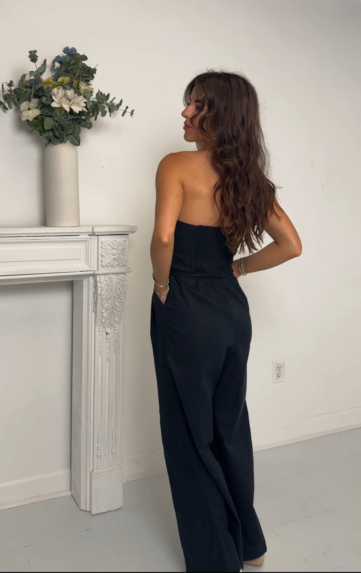 back of a navy strapless jumpsuit worn by someone in a studio