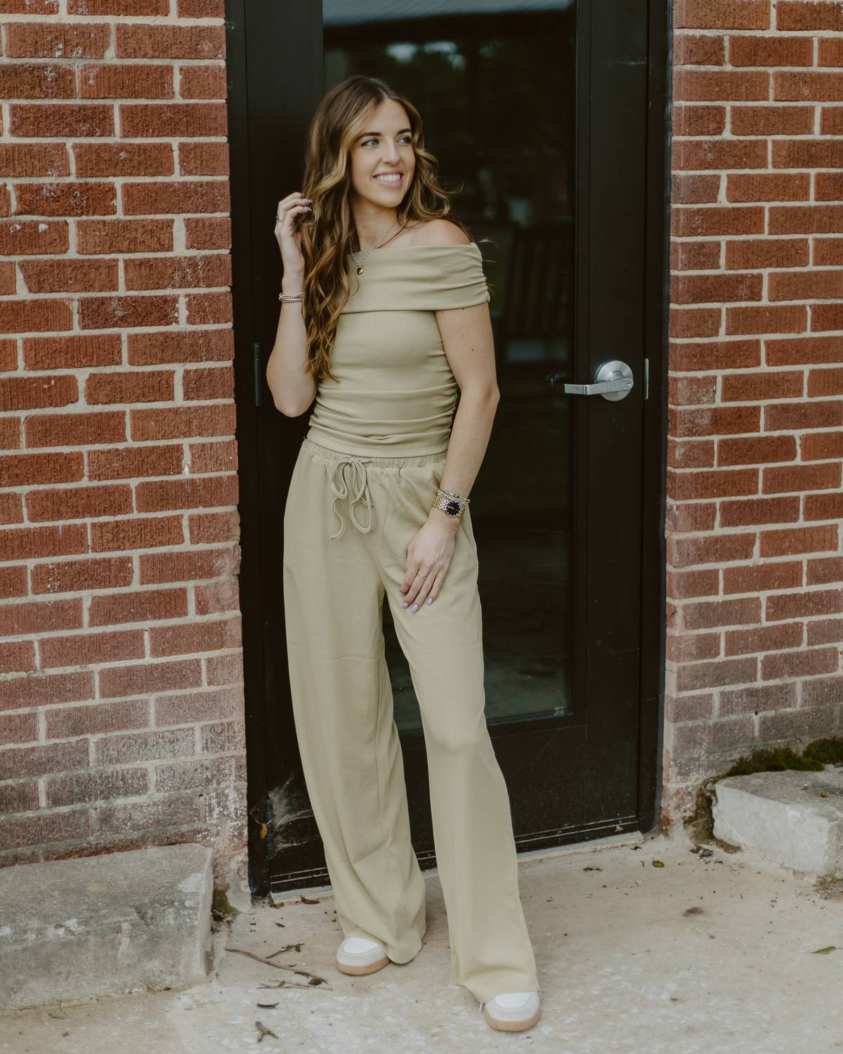 Woman wearing olive green off the shoulder pants set.