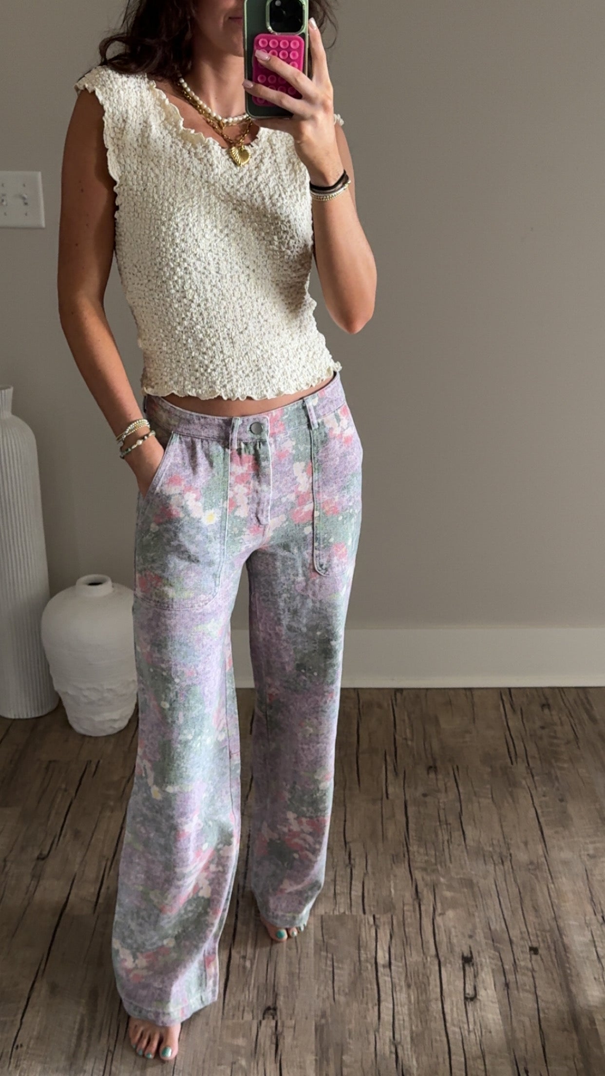 Person wearing a vanilla top and floral straight leg pants.