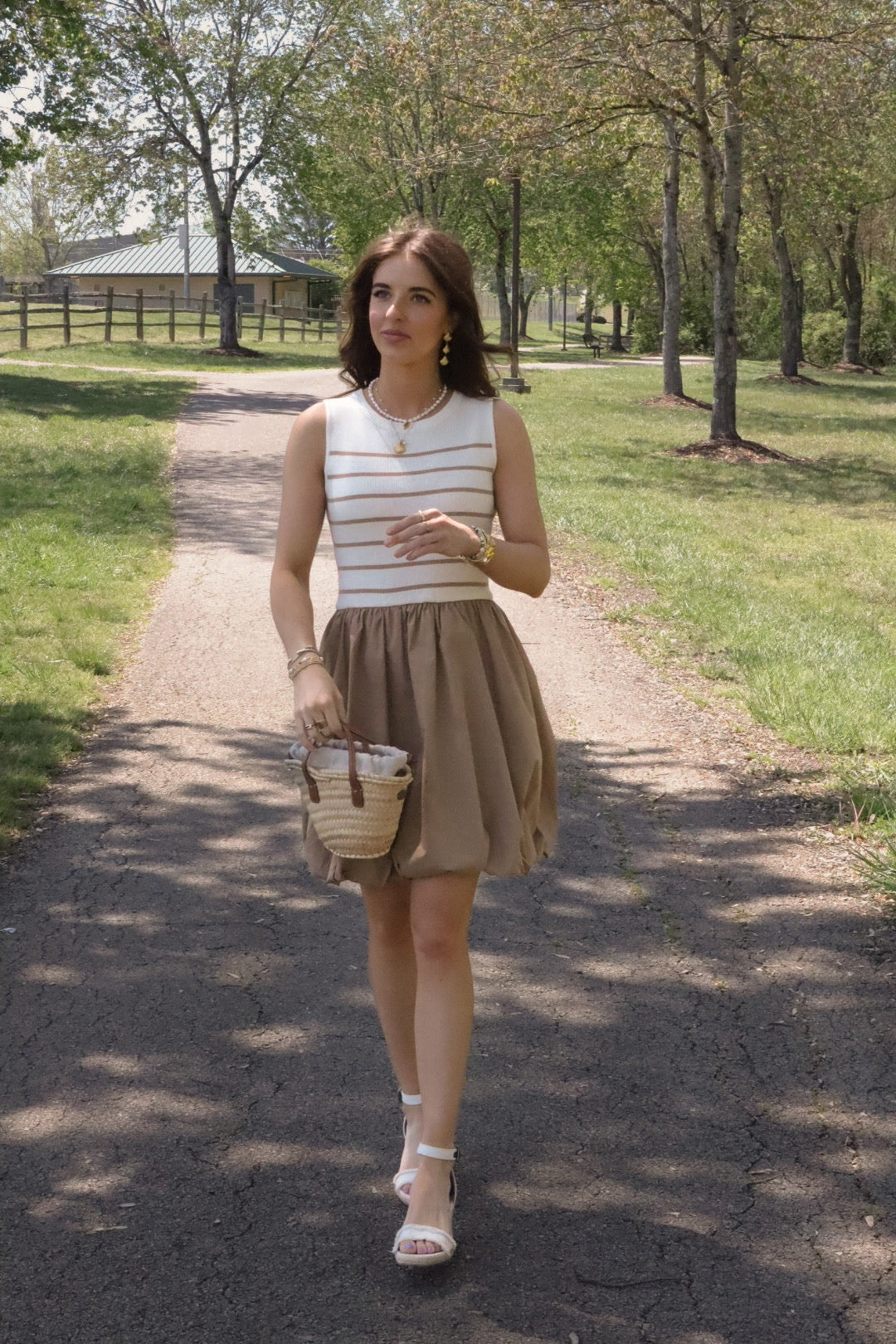 person walking in street wearing a white and tan striped bubble hem dress