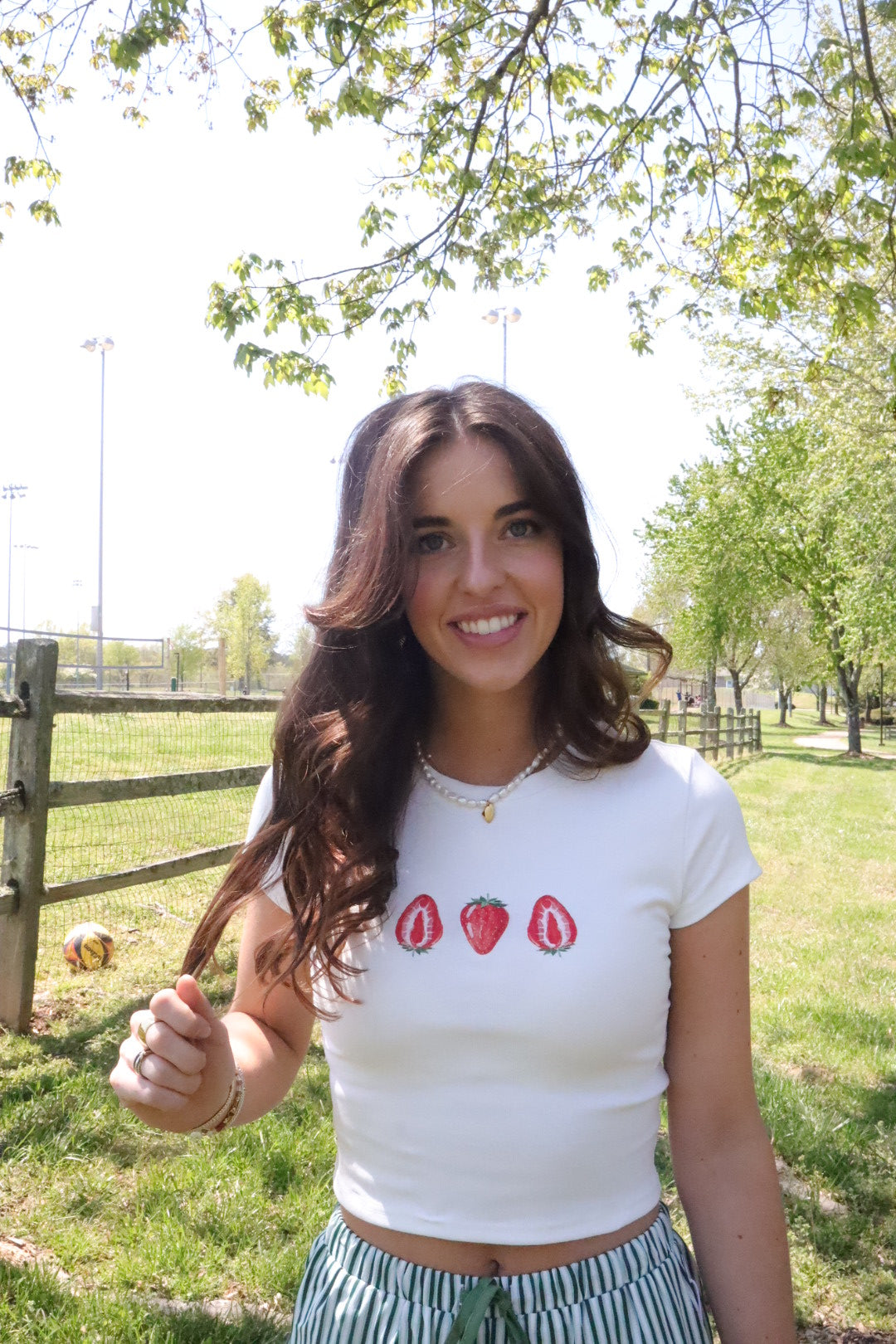 white tee shirt with strawberries printed on it. cropped design and for a summer picnic.