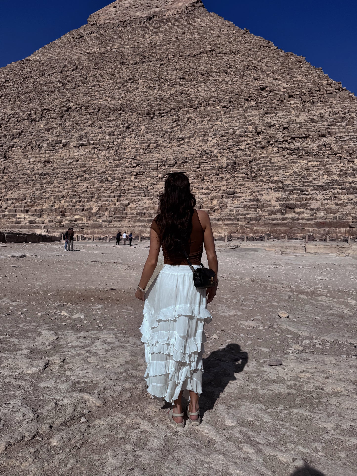 back of woman in a white ruffle flowy skirt