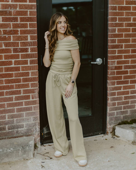 Woman wearing olive green off the shoulder pants set.