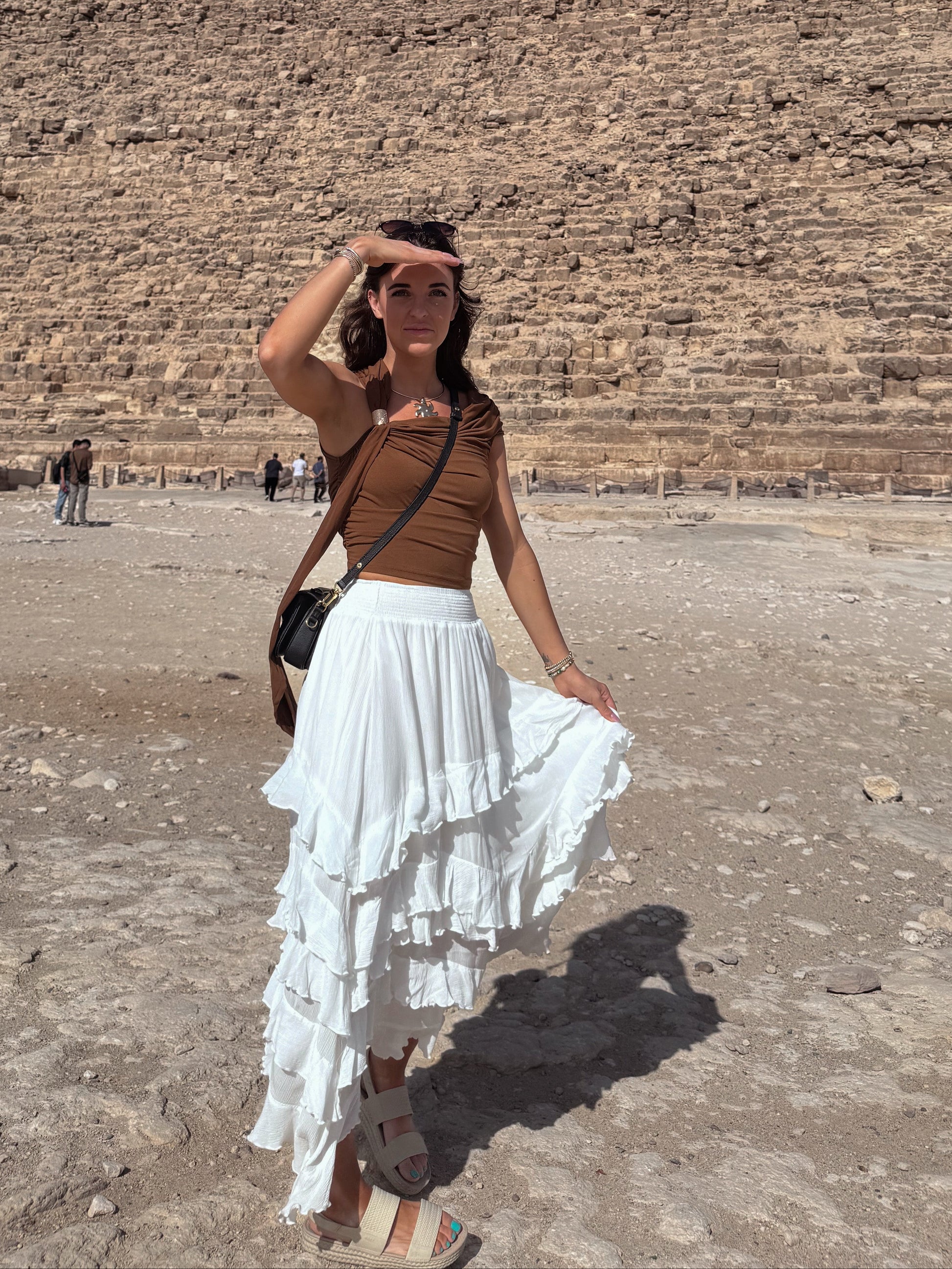 Woman standing in front of Pyramid with white ruffle flowy skirt